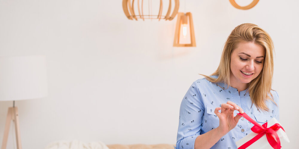Mevrouw pakt cadeau uit Een vrouw maakt een cadeautje open